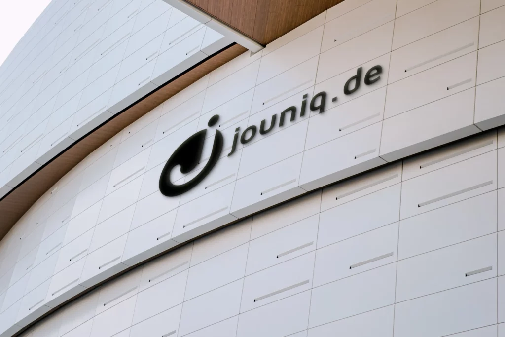 Kredit in 1 Stunde auf Konto ohne Schufa - Logo des Unternehmens jouniq.de auf einer Häuserwand.
